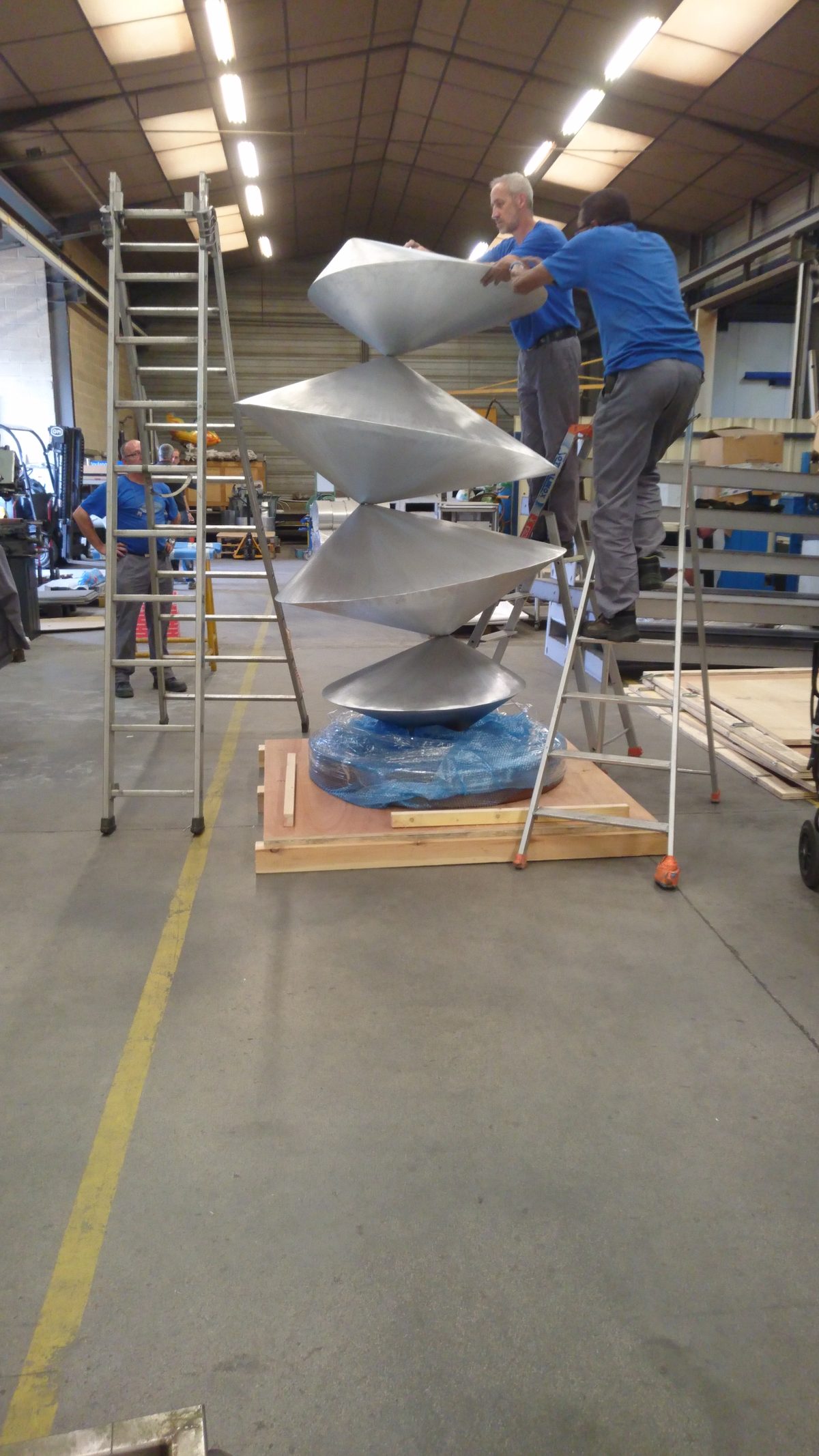 Les compagnons assemblent la sculpture de toupies dans l'atelier